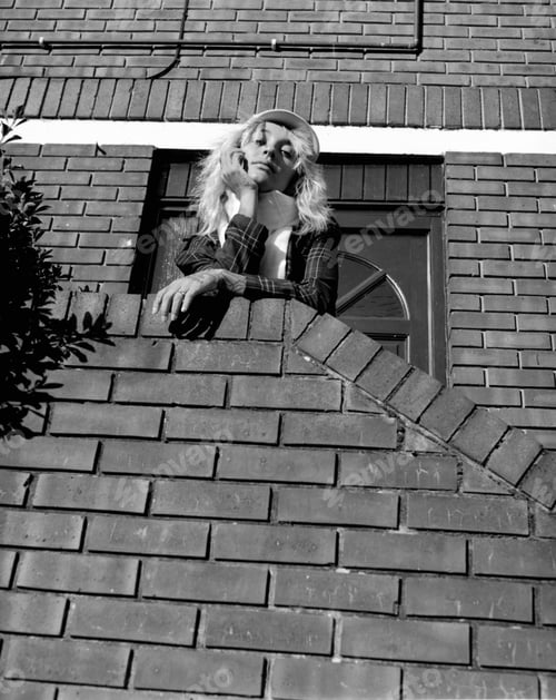 Preview: An alternative female model is looking at camera posing on stairs. Film analog.