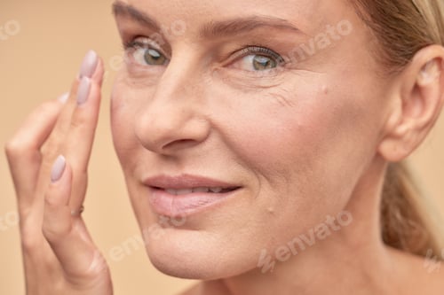Preview: Happy adult lady taking care of the health of her skin