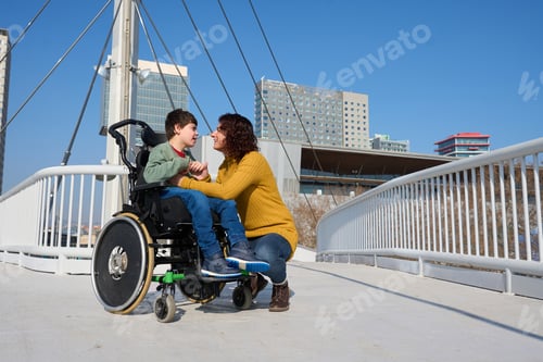 Preview: Mother comforting her son with cerebral palsy in a wheelchair on a bridge