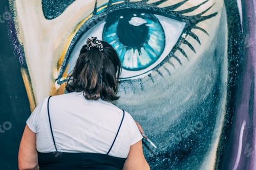 Visualização: Artista mulher pintando um grande mural de olhos azuis