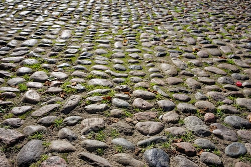 Preview: Background of a sidewalk made of oval-shaped natural stone of light lilac, gray color.