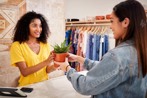 Female Customer Buying Plant From Sales Assistant In Independent Gift Store