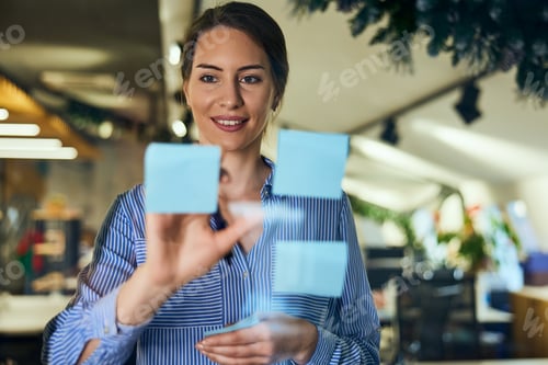 Preview: Confident Businesswoman Planning Strategy Using Sticky Notes in a Modern Office