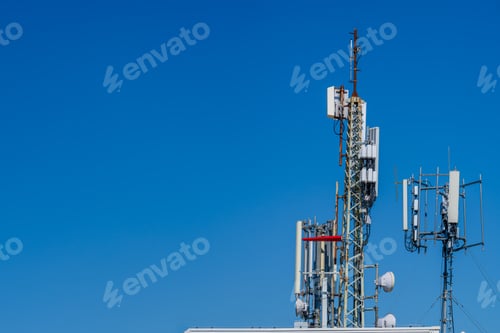 Preview: Close-up of tower with 6G, 5G, 4G cellular network antenna on blue sky background.