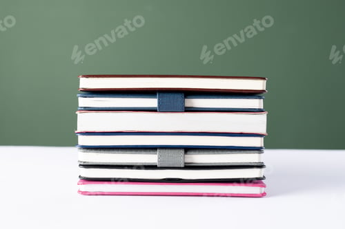 Preview: Close up of stack of books with copy space on green background