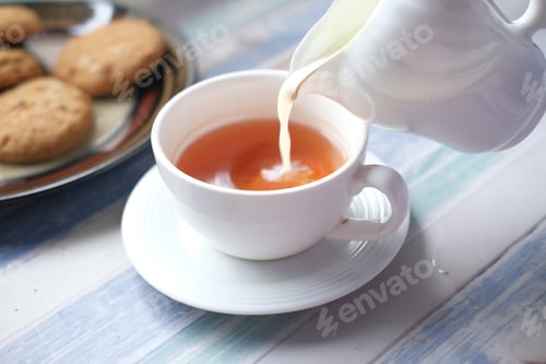 Preview: close up of pouring milk in a tea cup