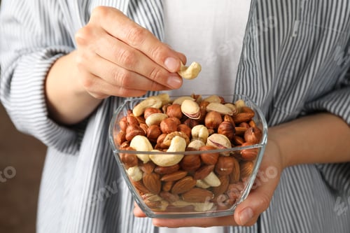 Preview: Woman hold bowl with different nuts. Healthy eating