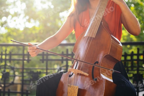 Preview: Cropped shot of an unrecognizable woman playing the cello outdoors