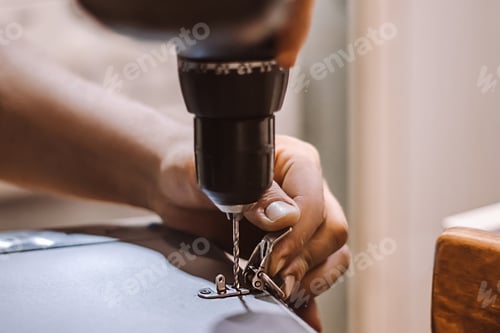 Preview: Male mechanic works with electric drill. Worker drills hole.