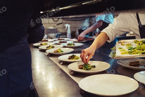Preview: Closeup shot of the chefs preparing a fine dinner at the kitchen in a restaurant in London, England