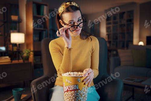 Preview: Funny woman watching TV and looking over glasses