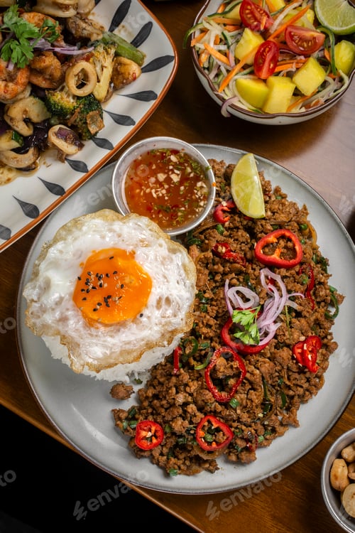 Preview: Pad Kra Pao Pork and Holy Basil Stir fry thai food meal on table at restaurant in thailand