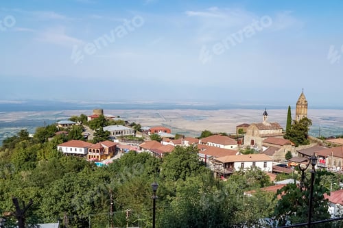 Preview: sunlight on houses near green trees against blue sky