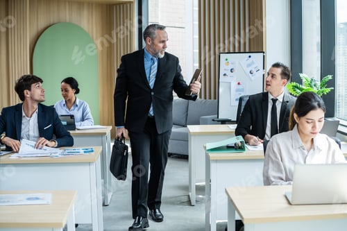 Visualização: Empresário caucasiano caminhando para a mesa de trabalho no local de trabalho do escritório.