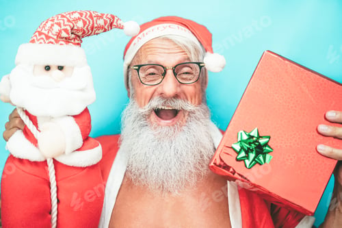 Preview: Happy trendy santa claus holding gift and christmas puppet