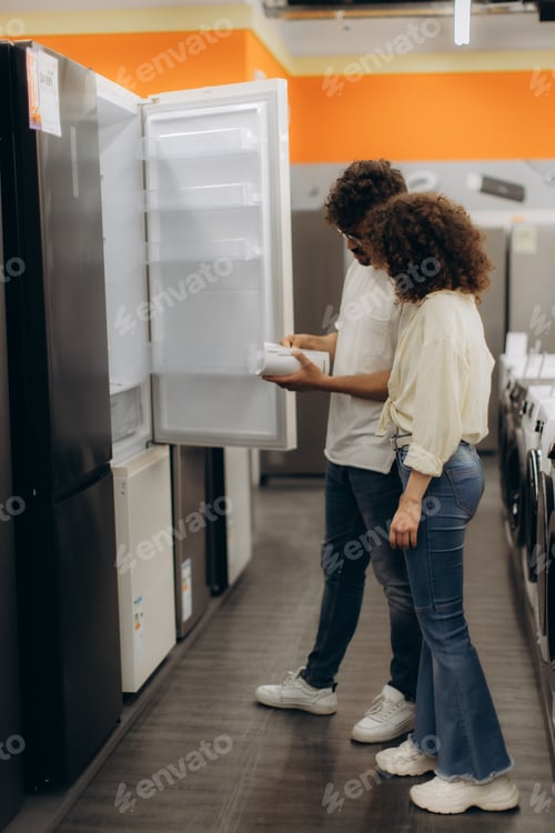 Preview: Couple Exploring Refrigerators in an Electronics Store Showroom