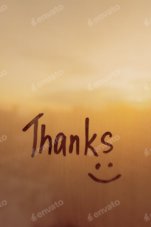 Preview: word Thanks are painted and smile on wet blue glass of window, vertical