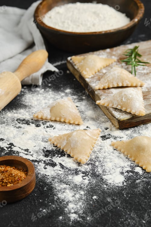 Preview: Freshly made ravioli on a kitchen counter with flour and spices