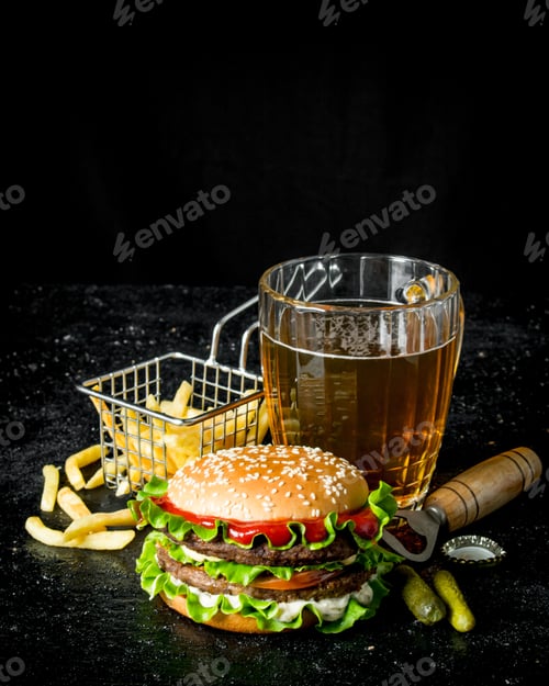 Preview: Burger with beer, fries and gherkins.