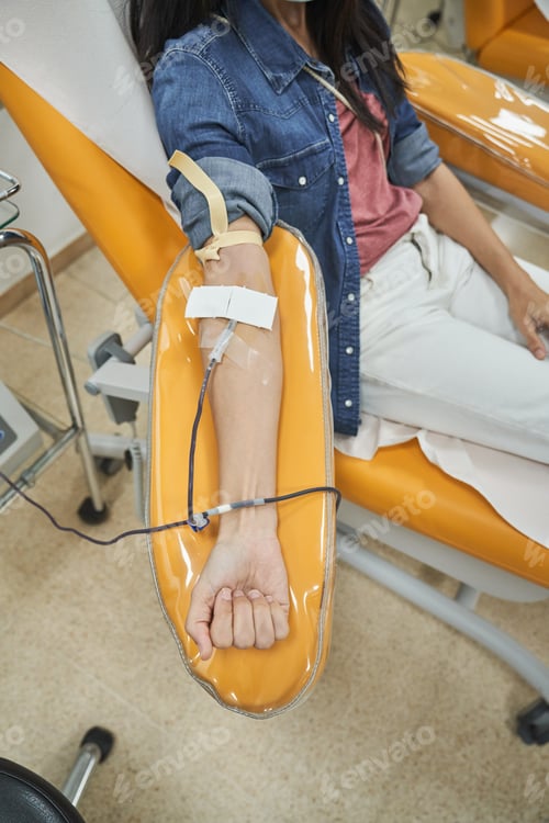 Preview: Unrecognizable woman giving blood in hospital