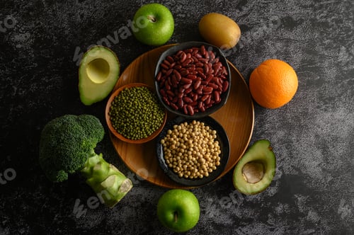 Preview: legumes and fruit on a black cement floor background.