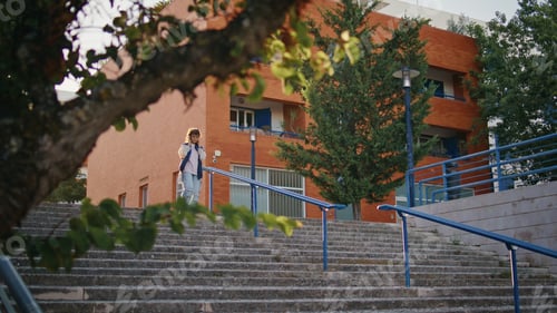 Preview: Casual girl walking downstairs exploring urban district. Woman going down stairs