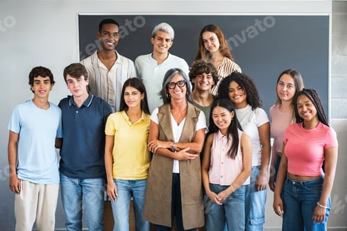 Preview: Group portrait of teenager students with senior teacher at school classroom