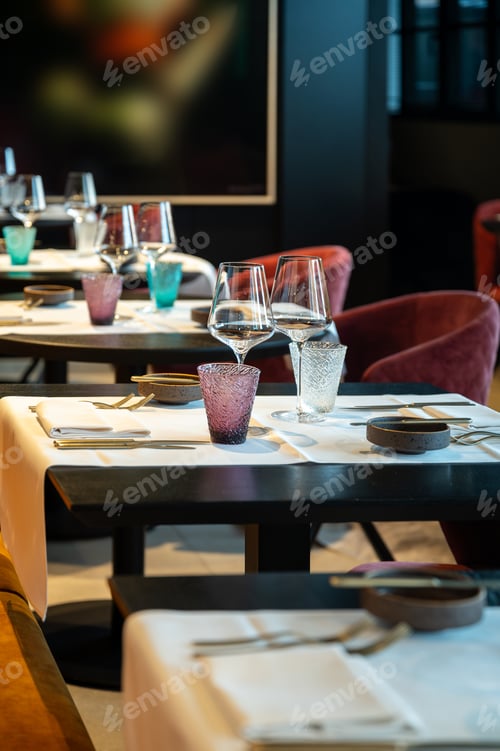 Elegant dinner setting. Sophisticated dining area decorated with white linens and ambient lighting