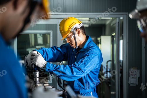 Preview: Asian mechanical workers working on milling machine.