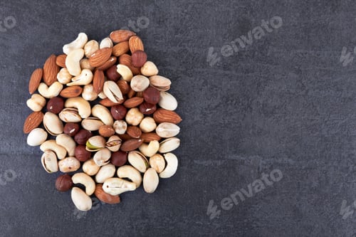 Preview: Heap of mixed nuts on black stone surface