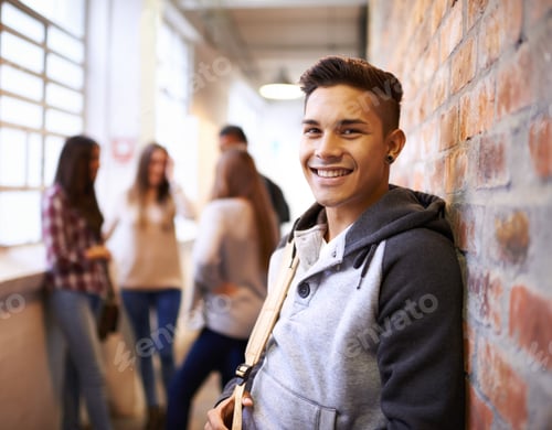Preview: Portrait of a handsome young male student leaning against a wall with his friends in the background