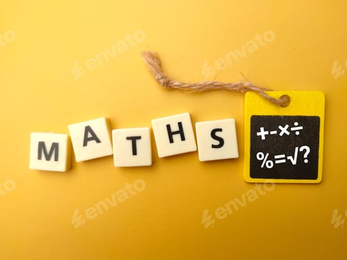 Preview: Cubes with the word MATHS and math symbols on blackboard on yellow background-education concept