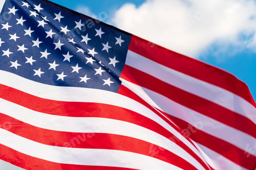Preview: American flag waving in the wind against blue sky