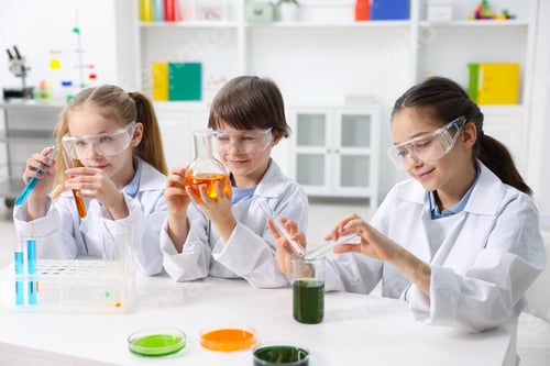 Preview: Children doing chemical experiment at desk indoors