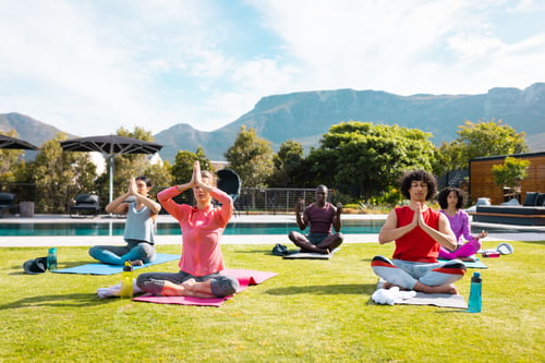 Preview: Diverse friends practicing yoga and meditating in garden