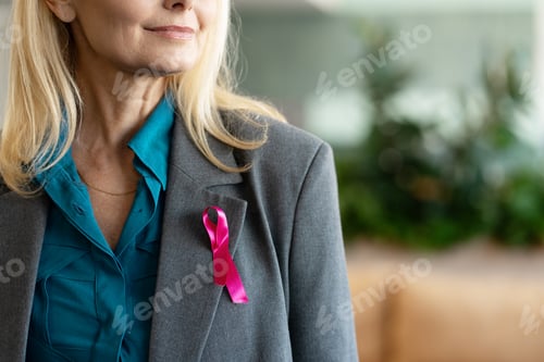 Preview: Businesswoman wearing pink ribbon showing support for breast cancer awareness