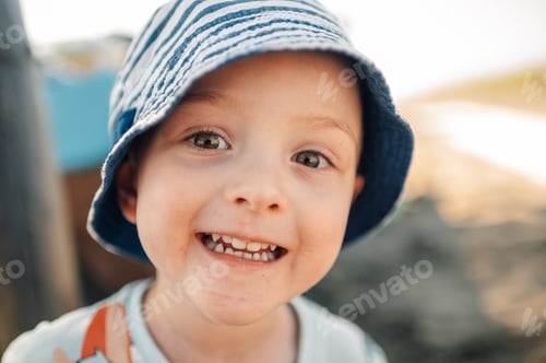 Preview: Close up cheerful little boy is looking at the camera and smiling.