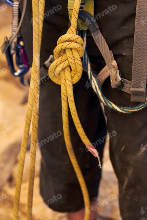 Preview: The perfect knot. Cropped shot of a young rock climber standing and adjusting his harnesses.