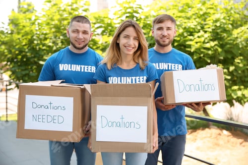 Preview: Young volunteers holding boxes with donations for poor people outdoors