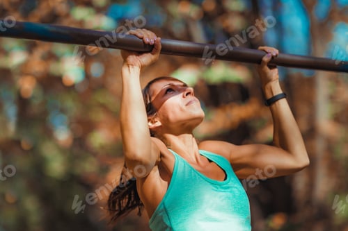 Preview: Woman doing pull-ups in the park