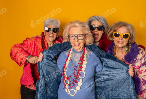 Preview: Four stylish senior women showing fashion and happiness on yellow background