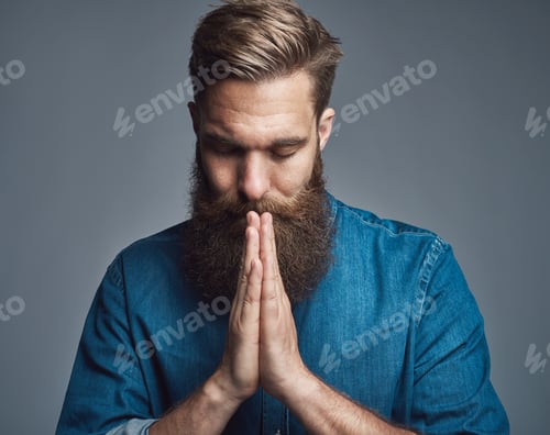 Preview: Prayerful bearded young man with palms together