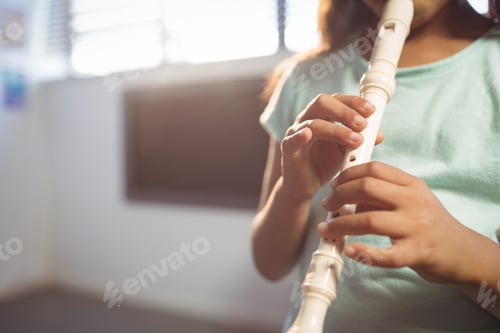 Preview: Mid section of girl playing flute in classroom