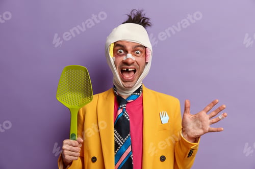 Preview: Funny positive man foolishes around at home, has fun at kitchen, shouts loudly, has brain concussion