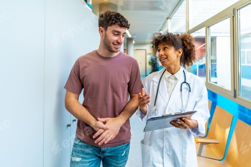 Preview: Female doctor explaining diagnosis to patient in hospital corridor