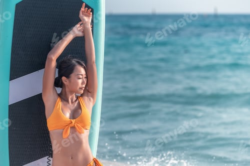 Preview: Portrait sexy beautiful Asian model wearing bikini swimming suite posing happy on beach with sup boa
