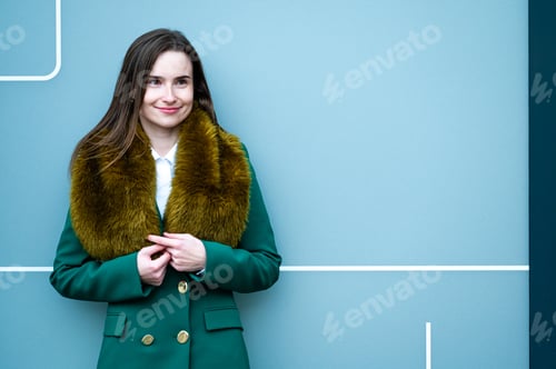 Preview: portrait of an elegantly dressed business woman near a blue wall of a modern office building