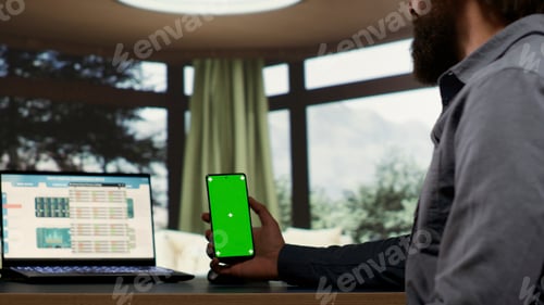 Preview: Adult millionaire looks at greenscreen smartphone display