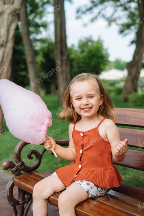 Preview: Smiling Girl Enjoying Cotton Candy in the Park