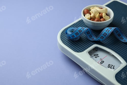 Preview: Scales with measuring tape and bowl of nuts on violet background